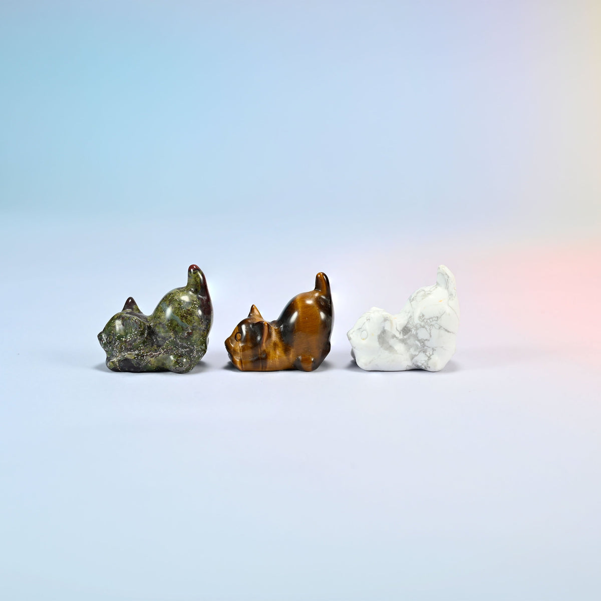 Natural dragon bloodstone, tiger eye and white howlite yoga cat carvings seen from the other side, polished smooth all round