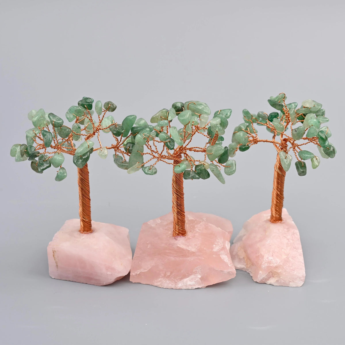 4 inch rose quartz gemstone tree with a copper wire trunk on a rough-cut rose quartz base