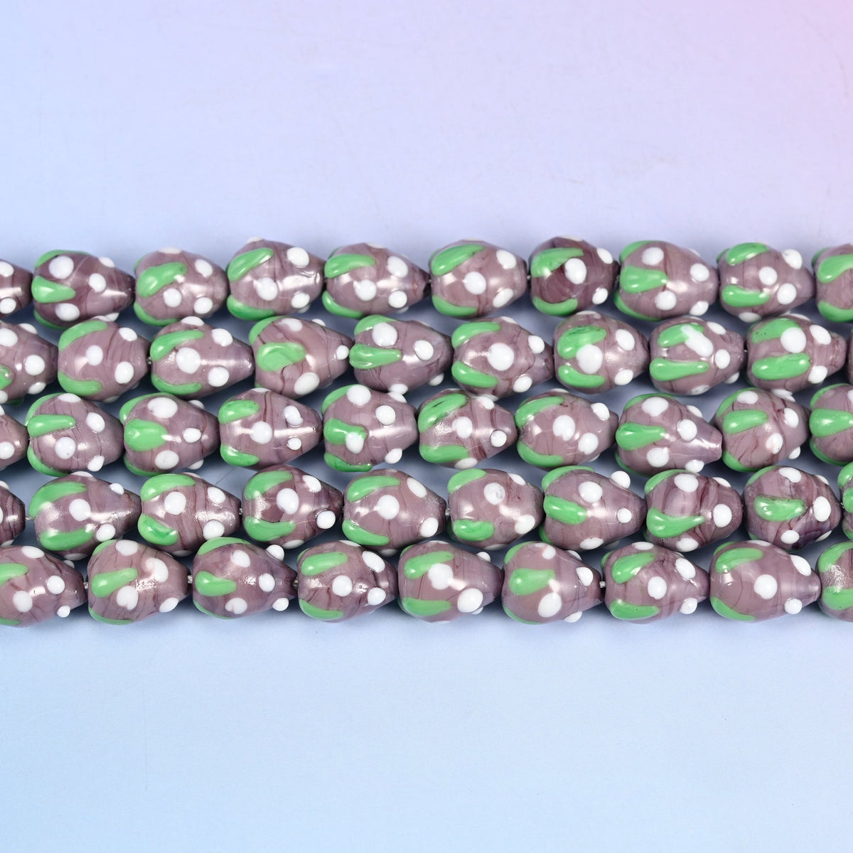 Purple White Dots Strawberry Glass Beads in muted mauve-purple with a bright green leaf band