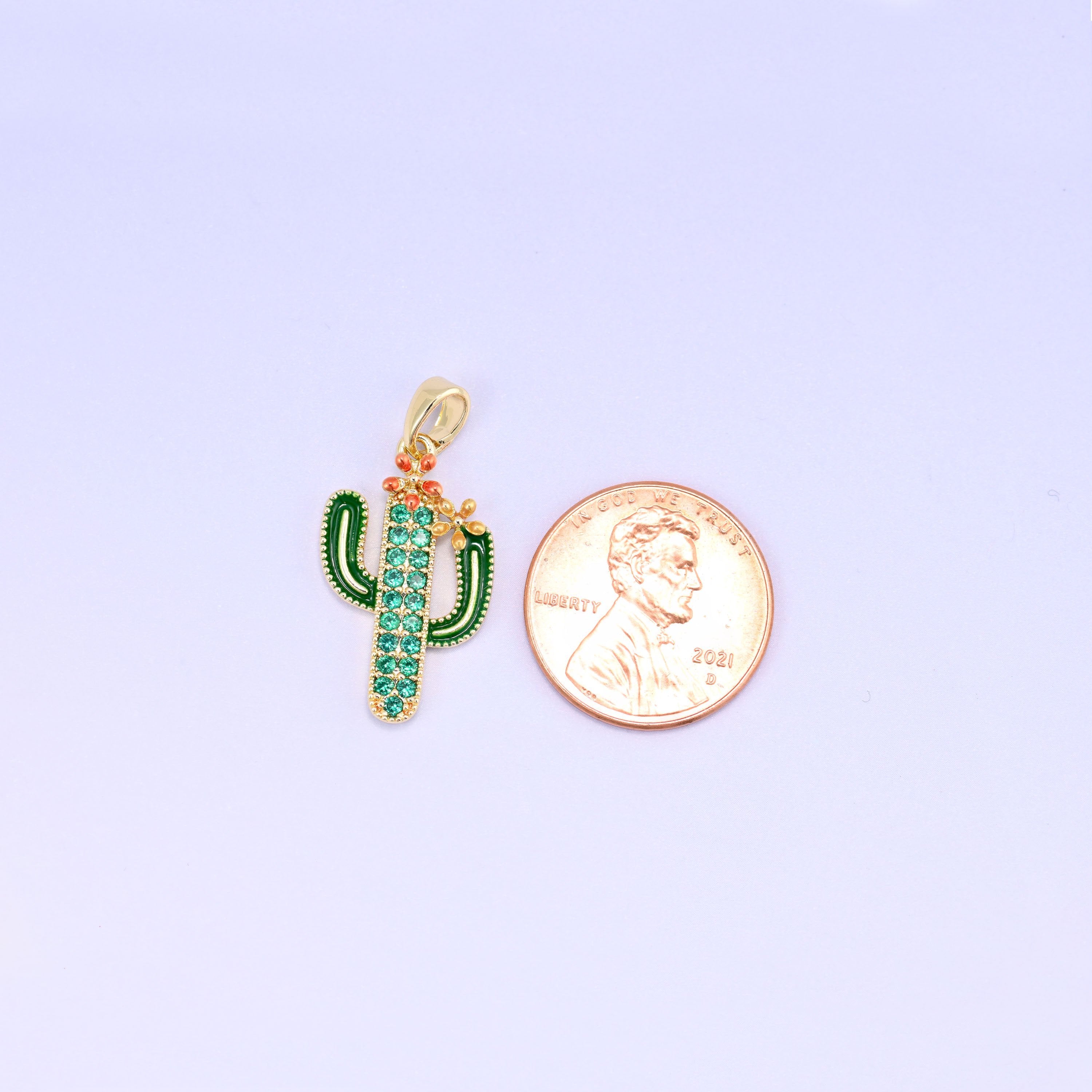 A little saguaro in green enamel with a pavé of green zircon running up the body and a coral blossom perched on one arm — desert kitsch done properly, in gold plated brass.