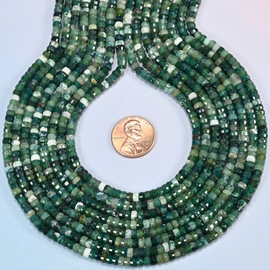 Moss agate faceted heishi disc strands formed into a teardrop loop around a US penny for scale
