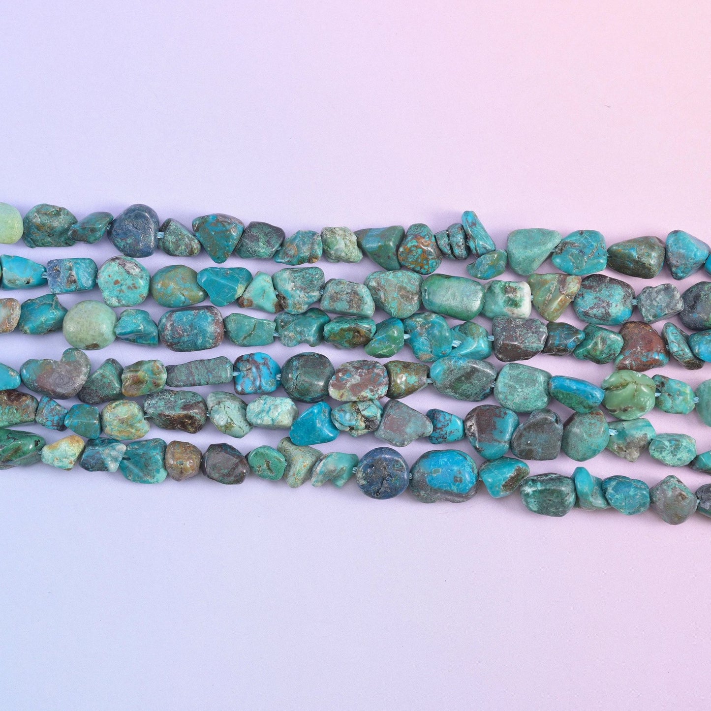 Four strands stretched flat, nugget shapes and sizes clearly varying along each row