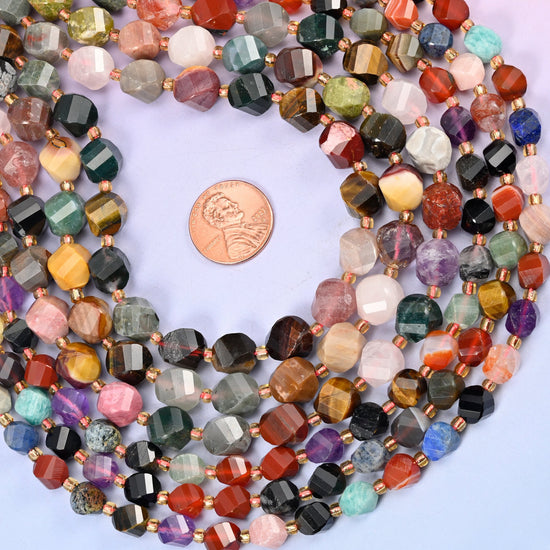 A full colour wheel of stones on one strand, each bead cut into a faceted barrel with the facets spiralling round it — violet amethyst, pale rose quartz, golden tiger's eye, jet black onyx