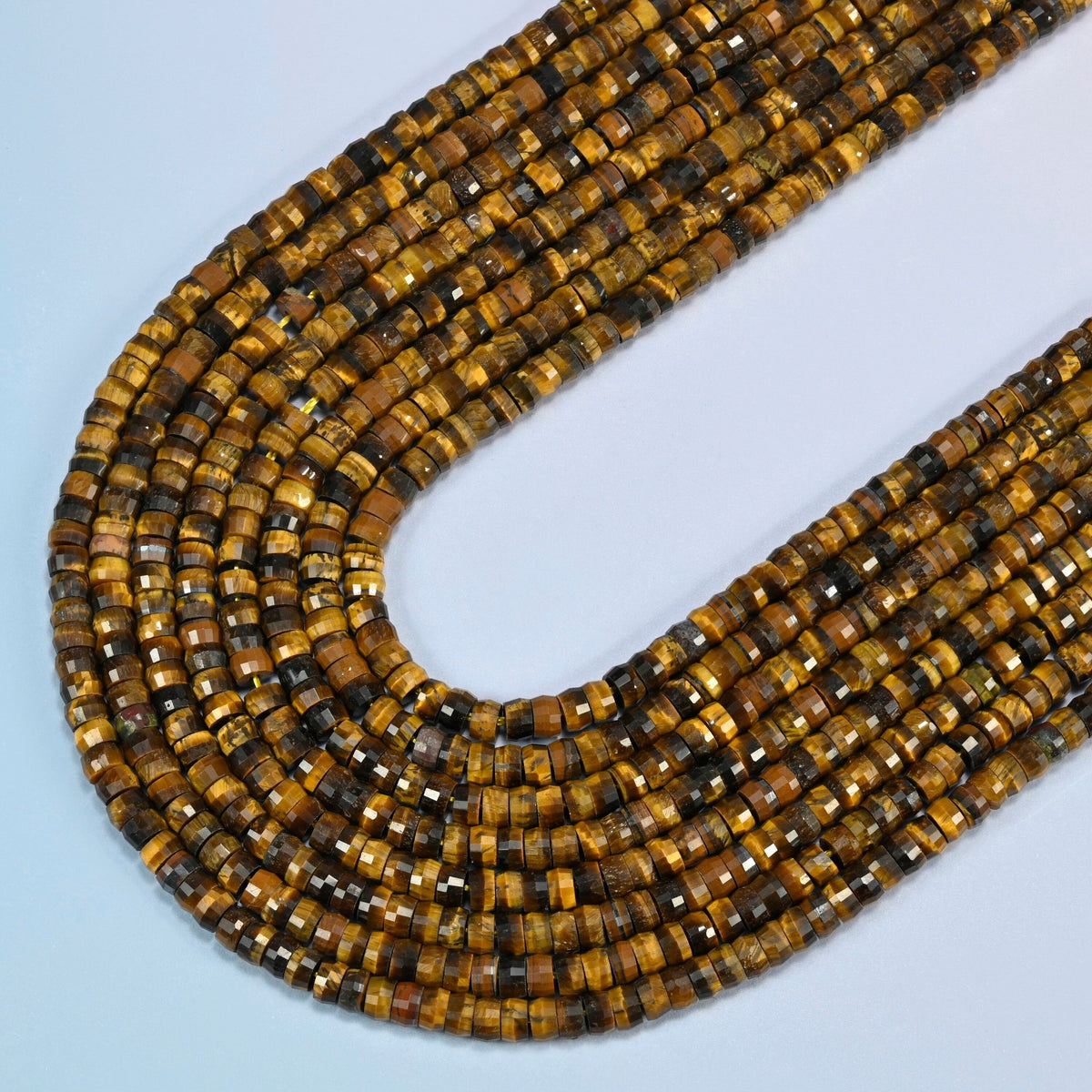 Tiger eye faceted heishi disc beads in several strands curved into a wide U, golden brown stone with a silky shimmer