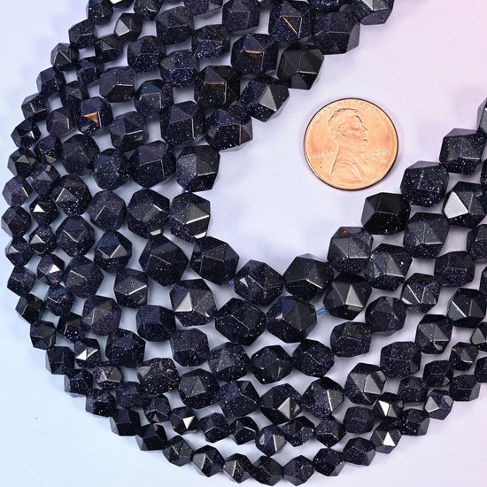 A penny lying across angled strands of midnight blue star cut beads for scale