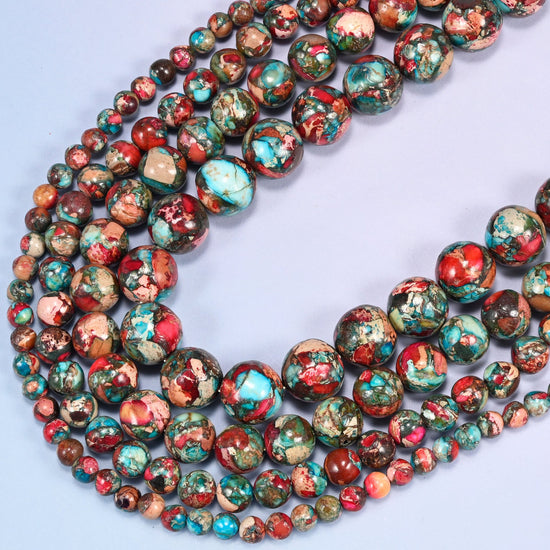 Red sea sediment jasper round beads, several strands looping in a wide curve across the frame.