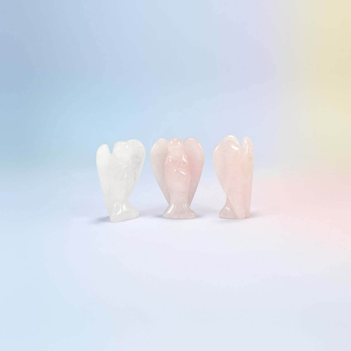 Three natural rose quartz guardian angel carvings, light pink, one nearly white, 2 inch