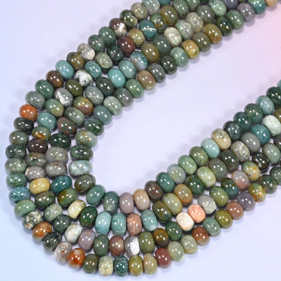 Close-up of Indian Agate rondelle beads coiled in a circular arrangement on a lavender background.
