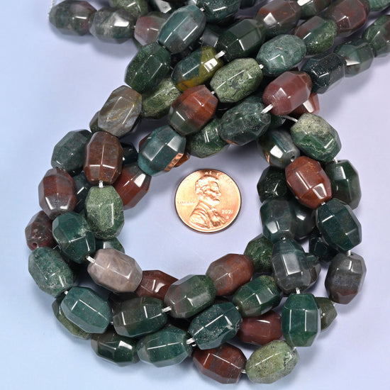 Close-up horizontal row of Indian Agate faceted barrel beads laid straight, showing the polished facet detail up close.