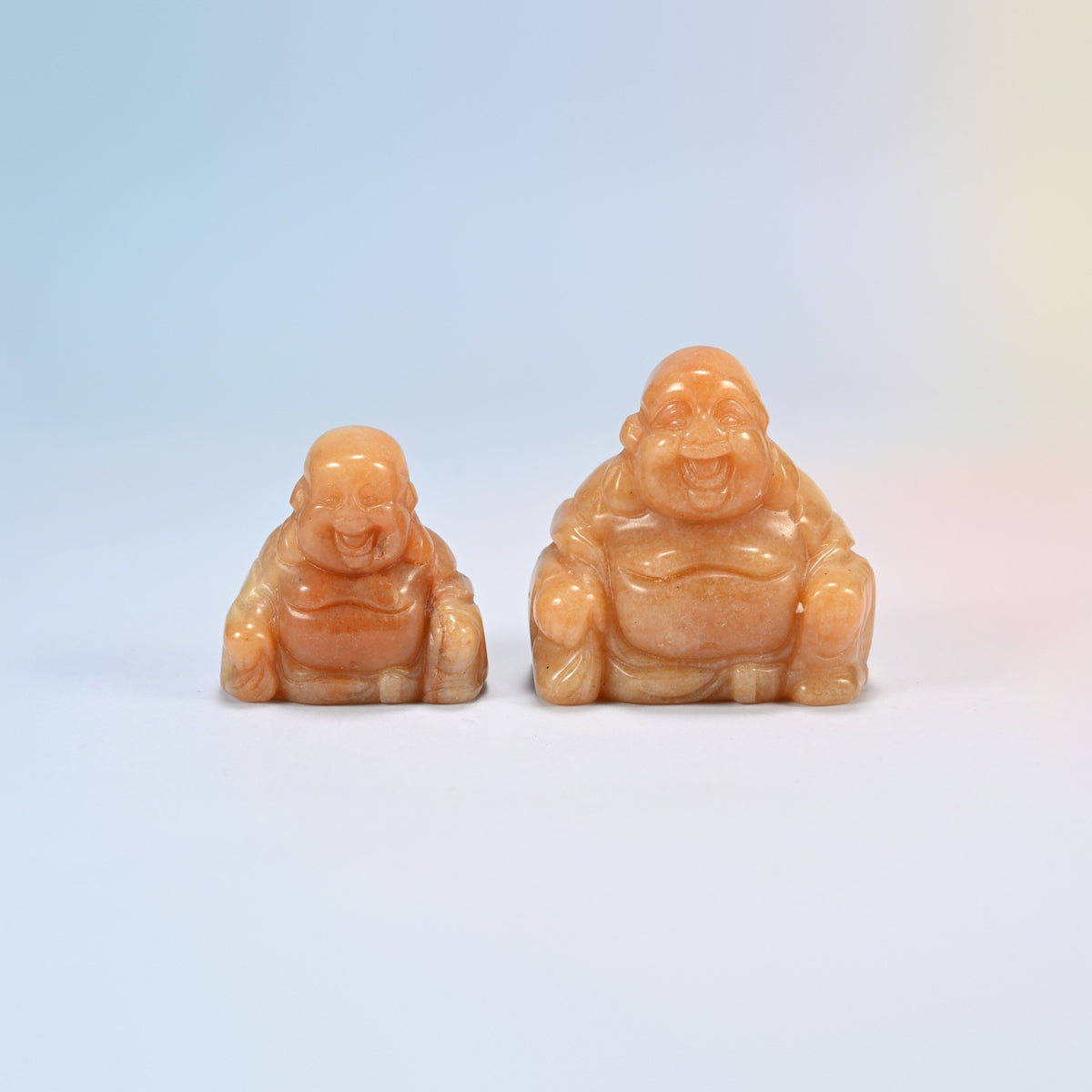 A 1.5 inch and a 2 inch red aventurine laughing Buddha crystal carving, warm orange natural stone