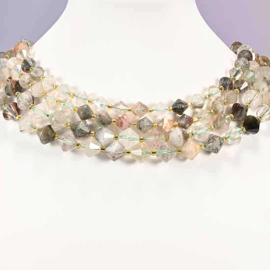 Strand of Green Phantom Quartz faceted bicone beads, 8mm and 10mm, worn on a jewelry display bust, showing the necklace-length drape.