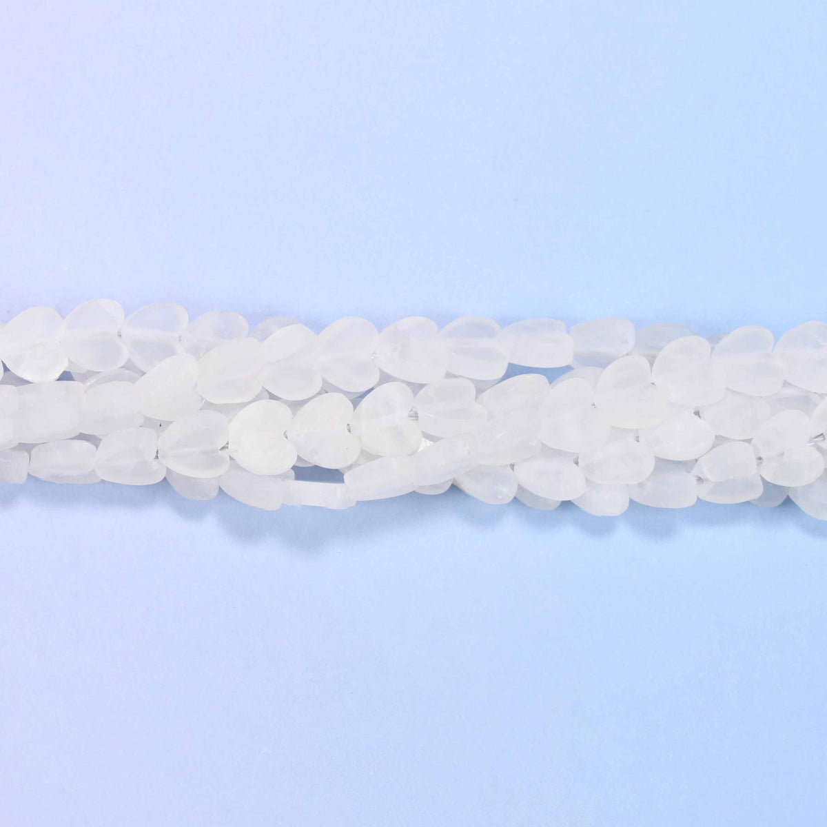 Matte clear quartz flat heart beads in frosted white, translucent enough for light to pass through but with no shine.