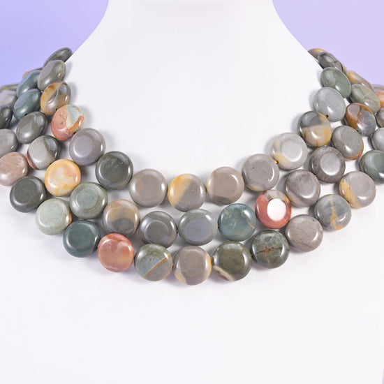 Three-strand picture jasper coin necklace on a white bust, grey and rust discs at the collarbone