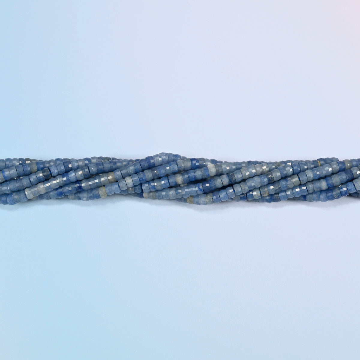 Strands of blue aventurine faceted heishi disc beads twisted together in a horizontal row