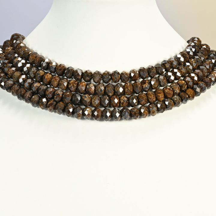 Bronzite faceted rondelle beads 5x8mm arranged as a layered collar on a white display bust, the bronze flecks catching the light
