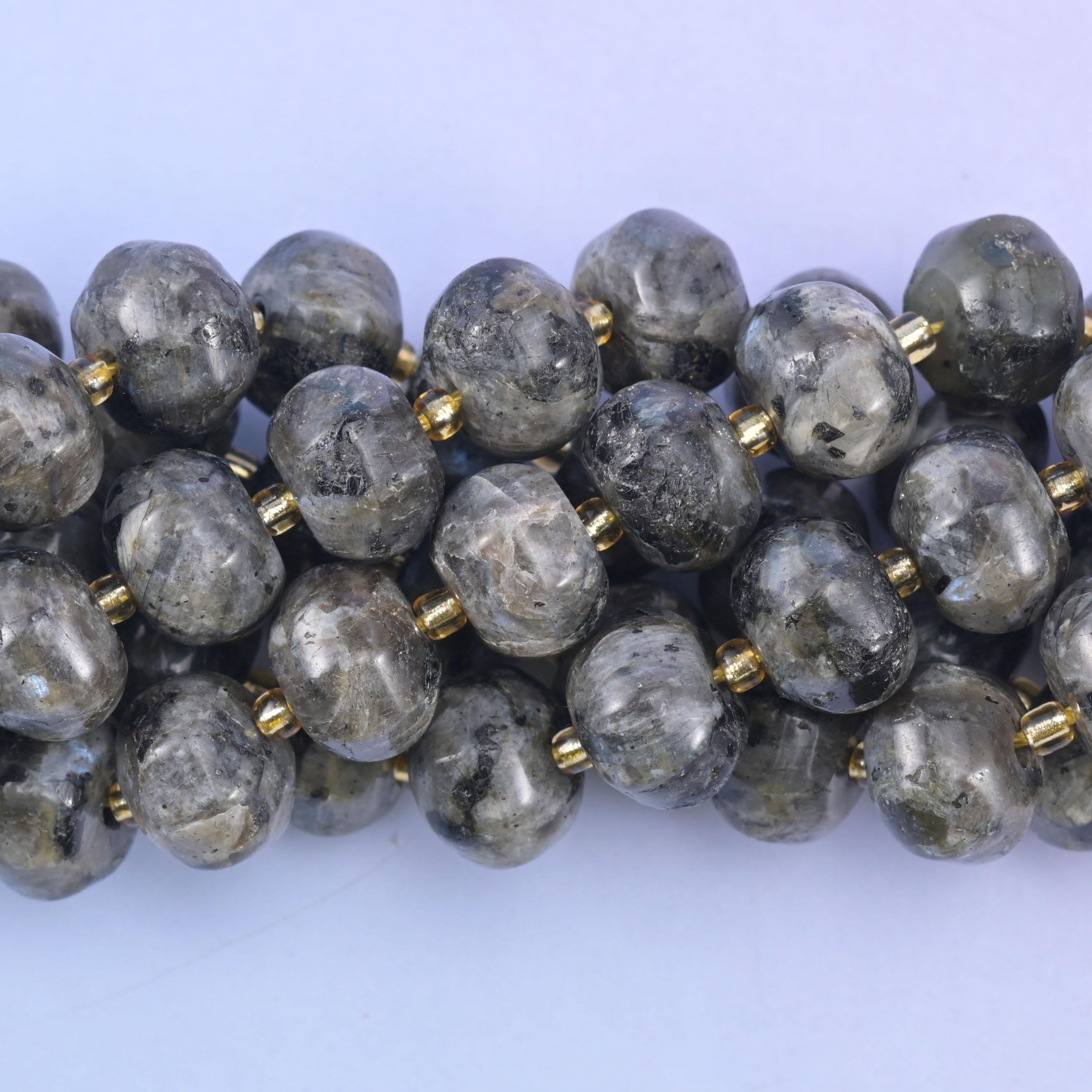 Close macro of grey labradorite pumpkin beads, silvery flecks scattered through the stone