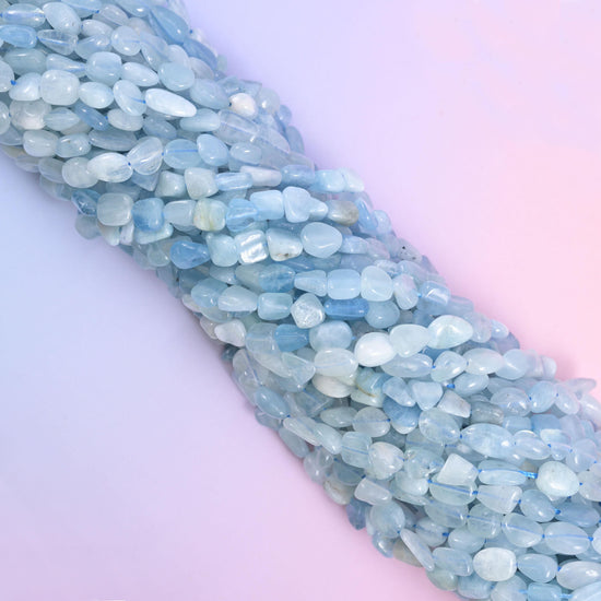 Aquamarine bead strands angled diagonally across a soft lilac background