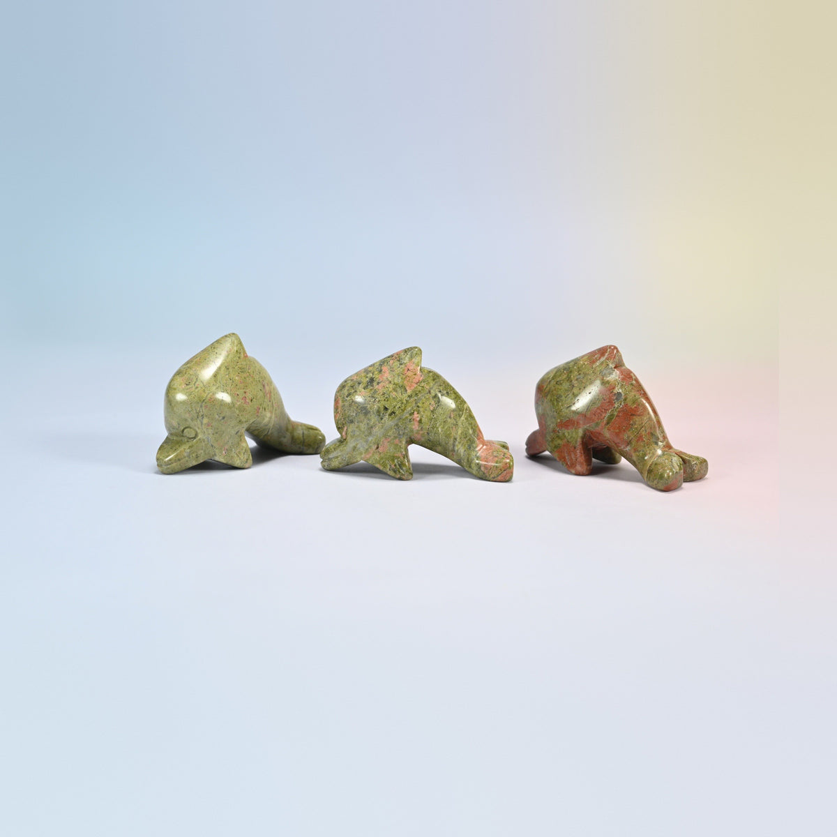 Three unakite dolphin crystal carvings, green and pink natural stone