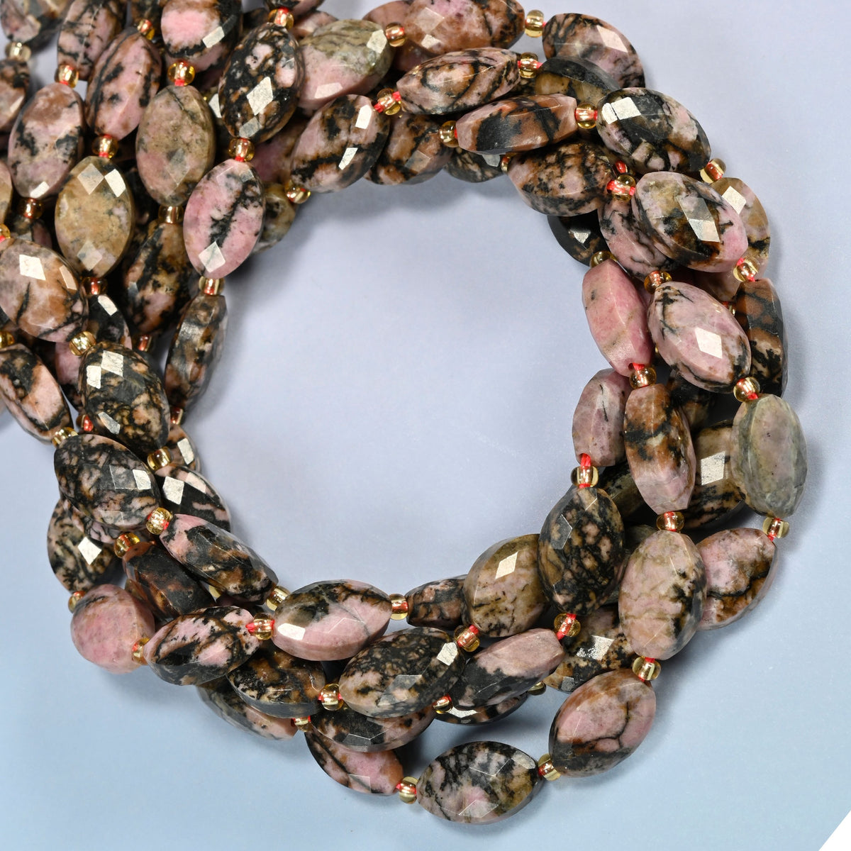 Rhodonite faceted flat oval beads coiled into overlapping loops, whole strands of pink and black stone