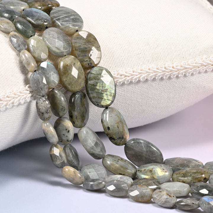 Gray Labradorite faceted oval beads draped in a soft curve, flat ovals in gray with green and gold tones