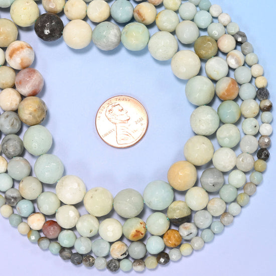 Multicolor amazonite faceted round beads in pale aqua and mint drifting into cream, sandy tan and grey tones, faceted so each bead picks up its own highlight.
