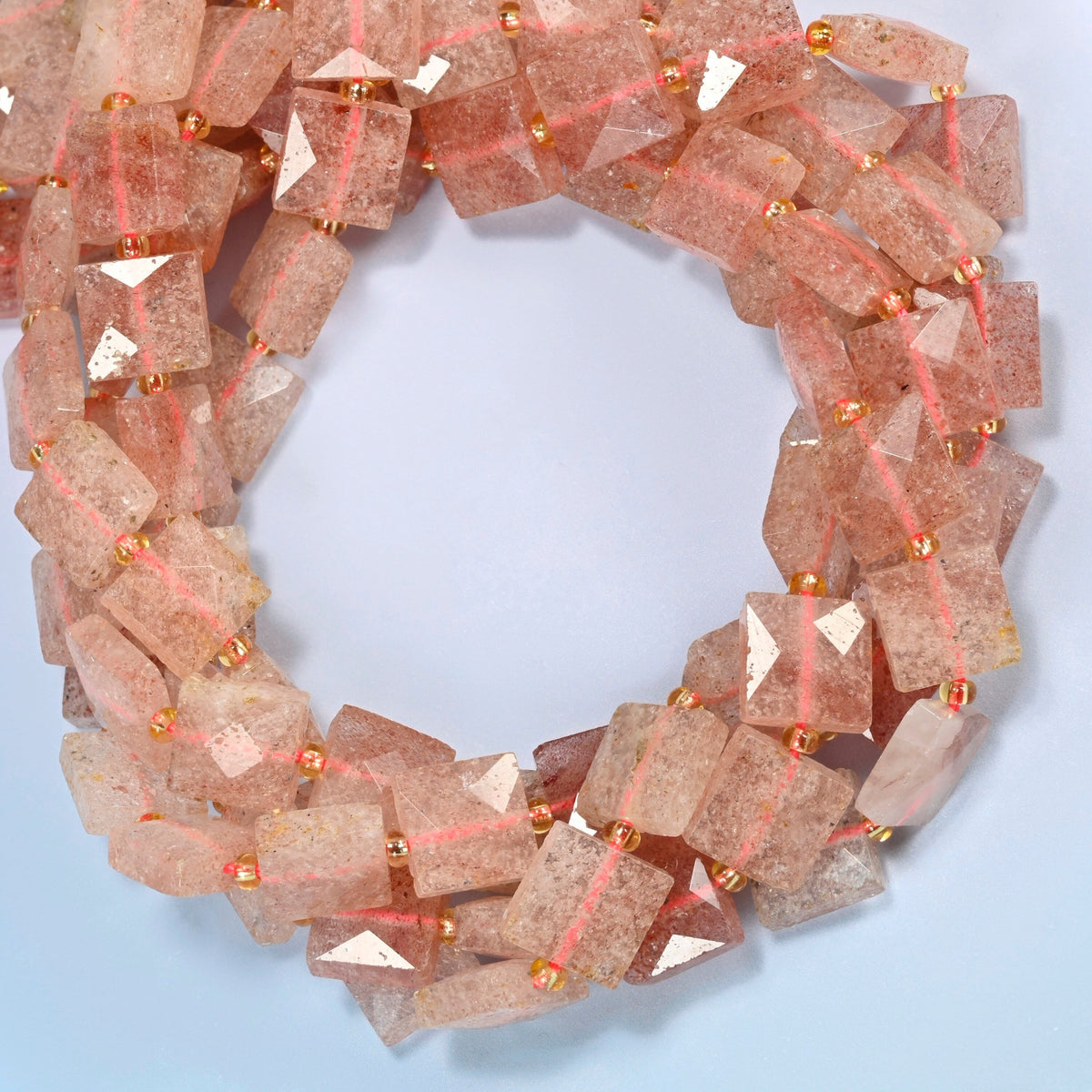 Natural strawberry quartz faceted flat square beads coiled into overlapping loops, whole strands of sparkly pink stone