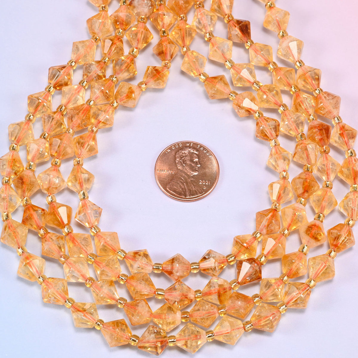 Citrine bicone beads coiled into a ring, seen from above, honey and amber tones sitting together.