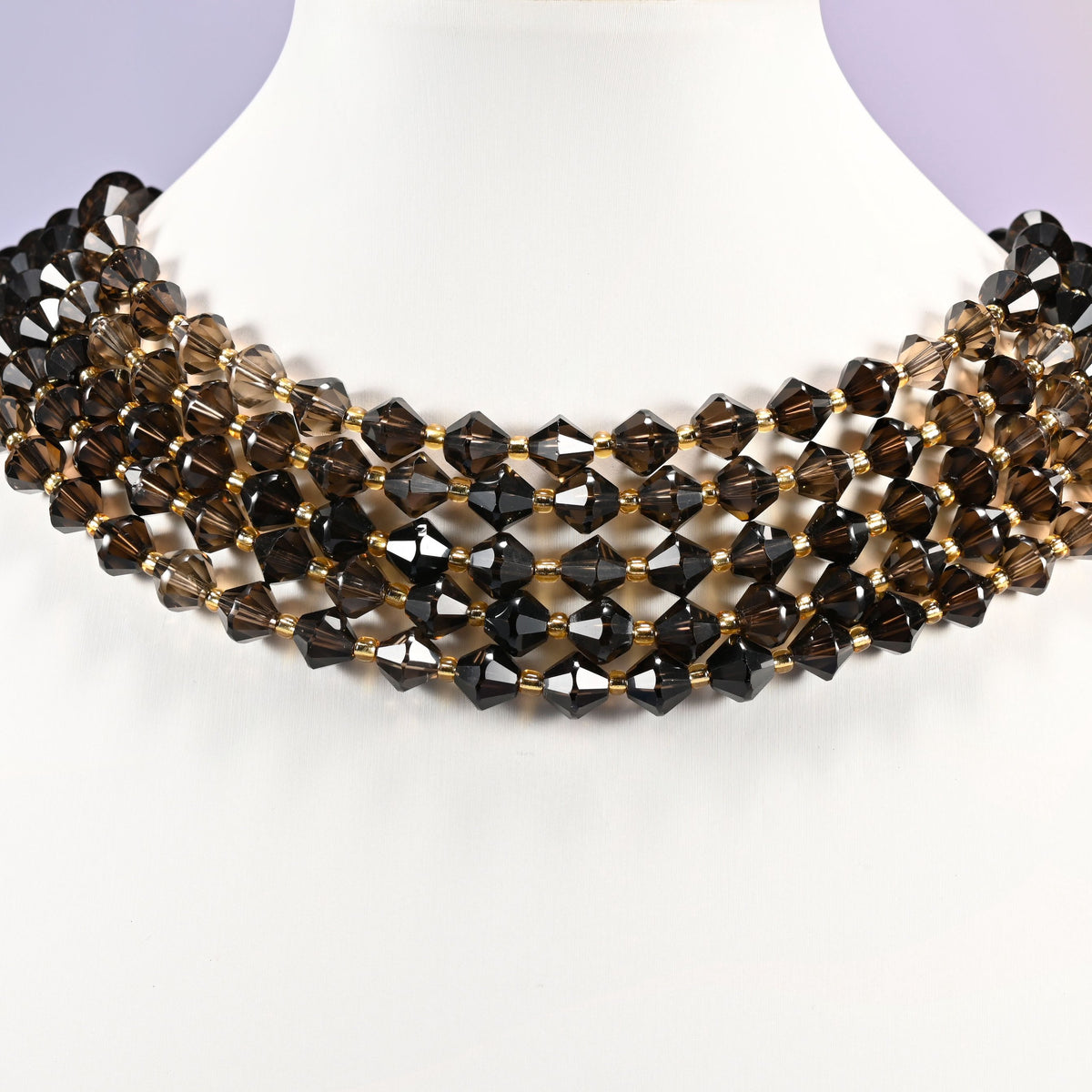 Strand of 8mm Smoky Quartz faceted bicone beads worn on a jewelry display bust, showing the necklace-length drape.
