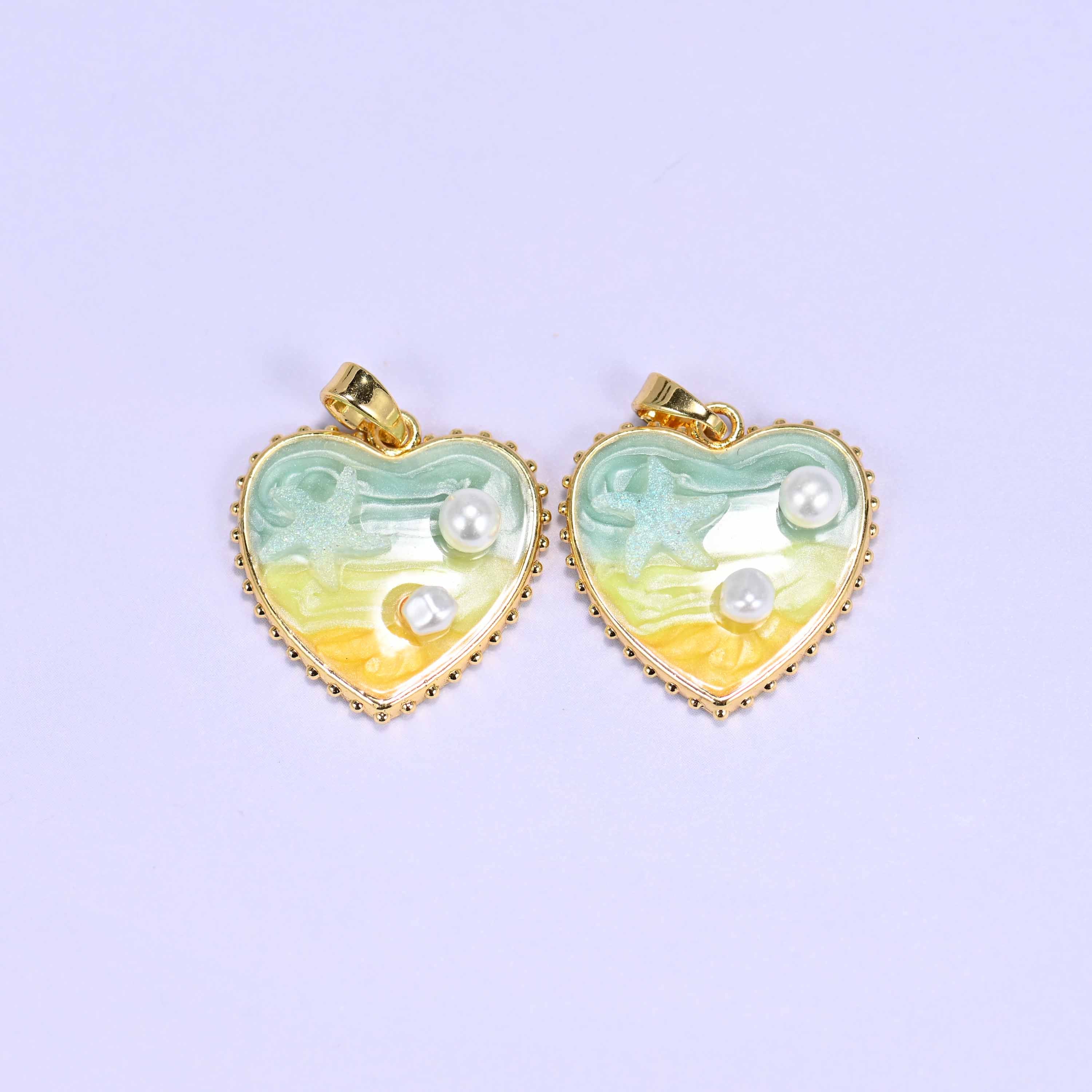 Enamel Heart Pendants in green, a close pair showing the raised starfish, the faux pearl beads and the dotted gold border.