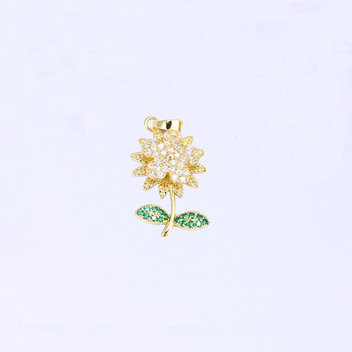 Gold plated flower charm with a spinning zirconia blossom and green leaves on the stem
