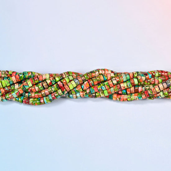 Strands of dyed blue green sea sediment jasper heishi disc beads 2x4mm twisted together in a horizontal row
