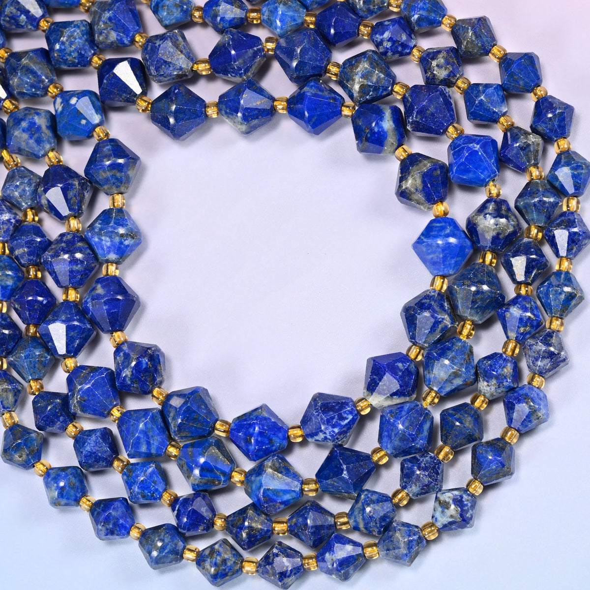 Lapis lazuli bicone beads formed into a wide open ring, bright facet highlights standing out against the dark blue.