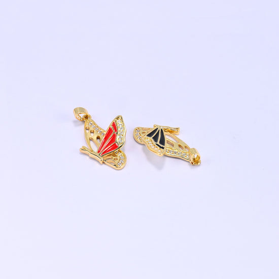 Red and black flying butterfly charm pendants together, the red charm upright and the black one resting on its side to show the wing profile.