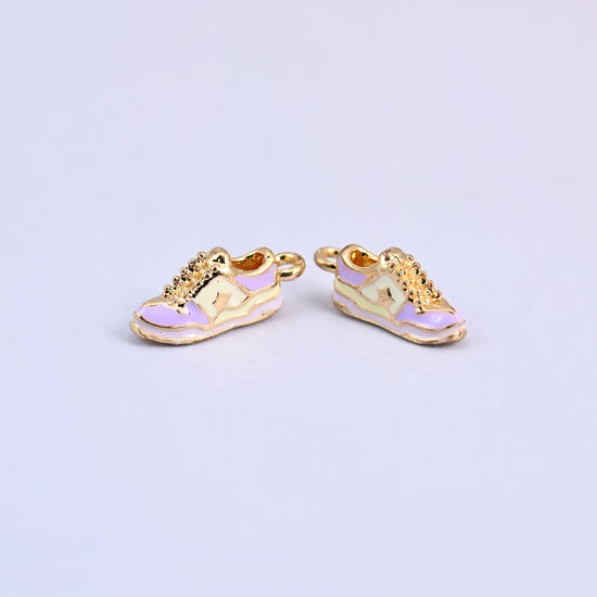 Two light purple sneaker charms with light yellow panels and gold laces.