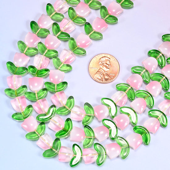 Close-up of a dense circular coil of pink tulip and green leaf glass beads, showing the alternating flower and leaf pattern.