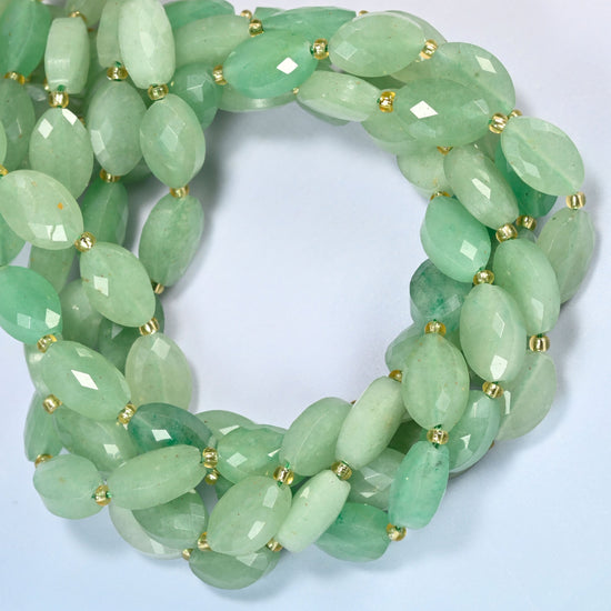 Green aventurine faceted flat oval beads coiled into overlapping loops, whole strands of soft green stone