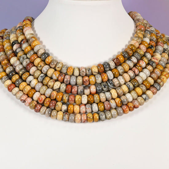 Multi-strand Crazy Agate necklace laid flat on a mannequin neck form against a lavender background.