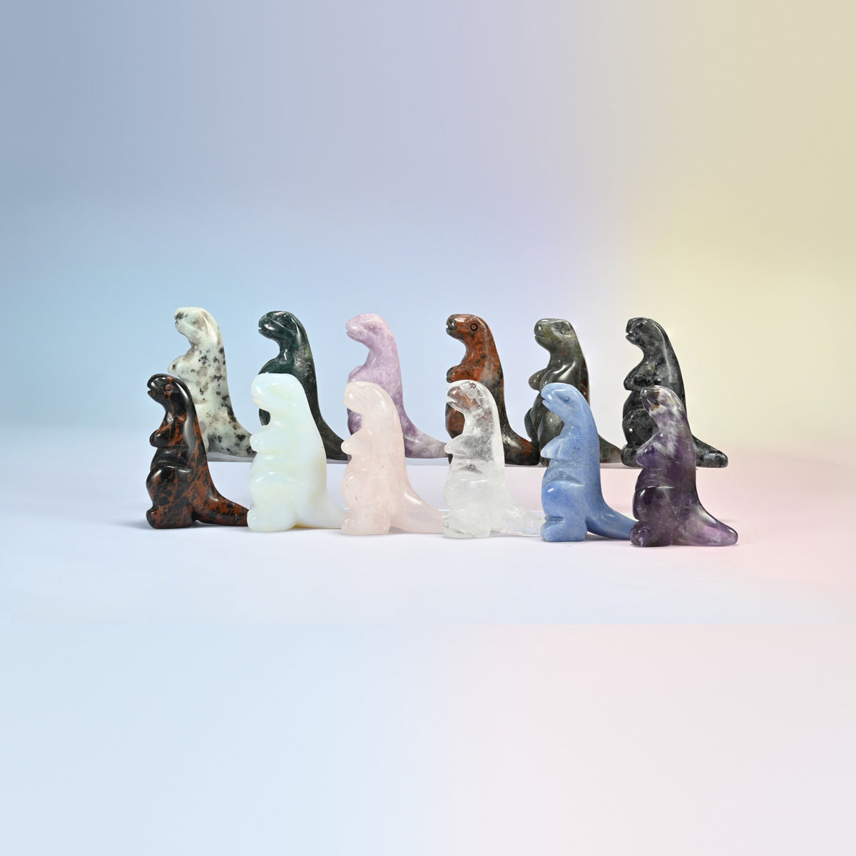 Group of 2 inch T-Rex dinosaur crystal carvings in natural kiwi jasper, Indian agate, rose quartz, golden swan, labradorite, clear quartz, blue aventurine and amethyst
