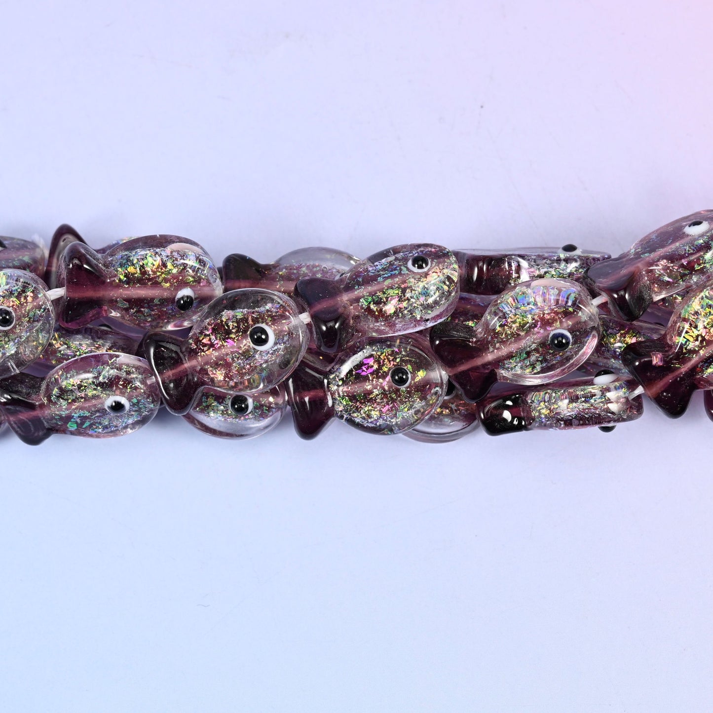 Iridescent purple fish glass beads, approximately 20 pieces per strand