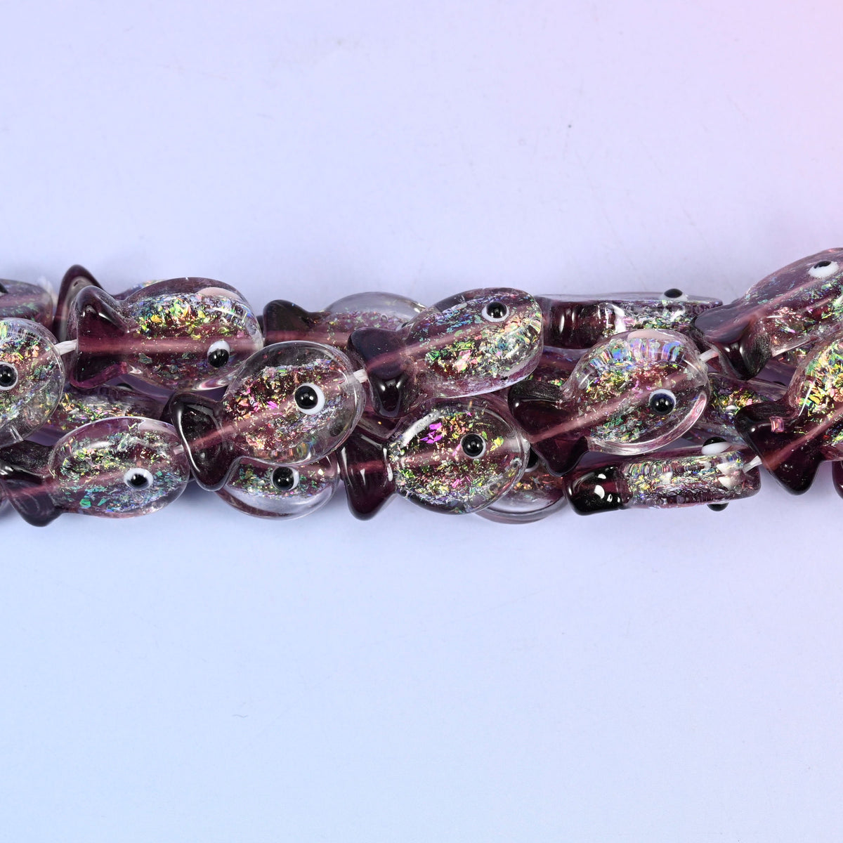 Iridescent purple fish glass beads, approximately 20 pieces per strand