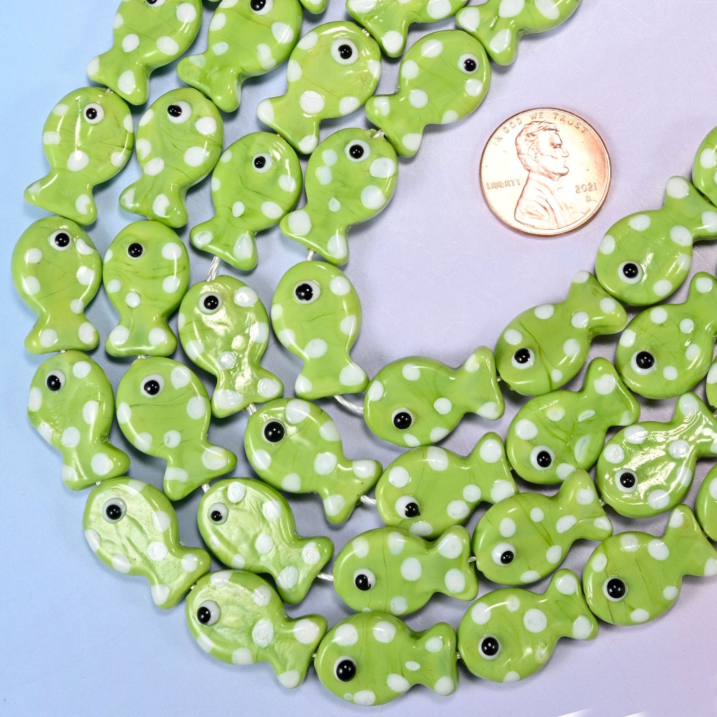 Fish-shaped lime green glass beads with white dot pattern