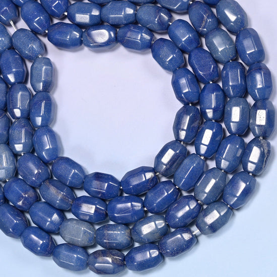 Close-up of a dense circular coil of blue faceted Aventurine barrel beads, showing the octagonal facet cuts.