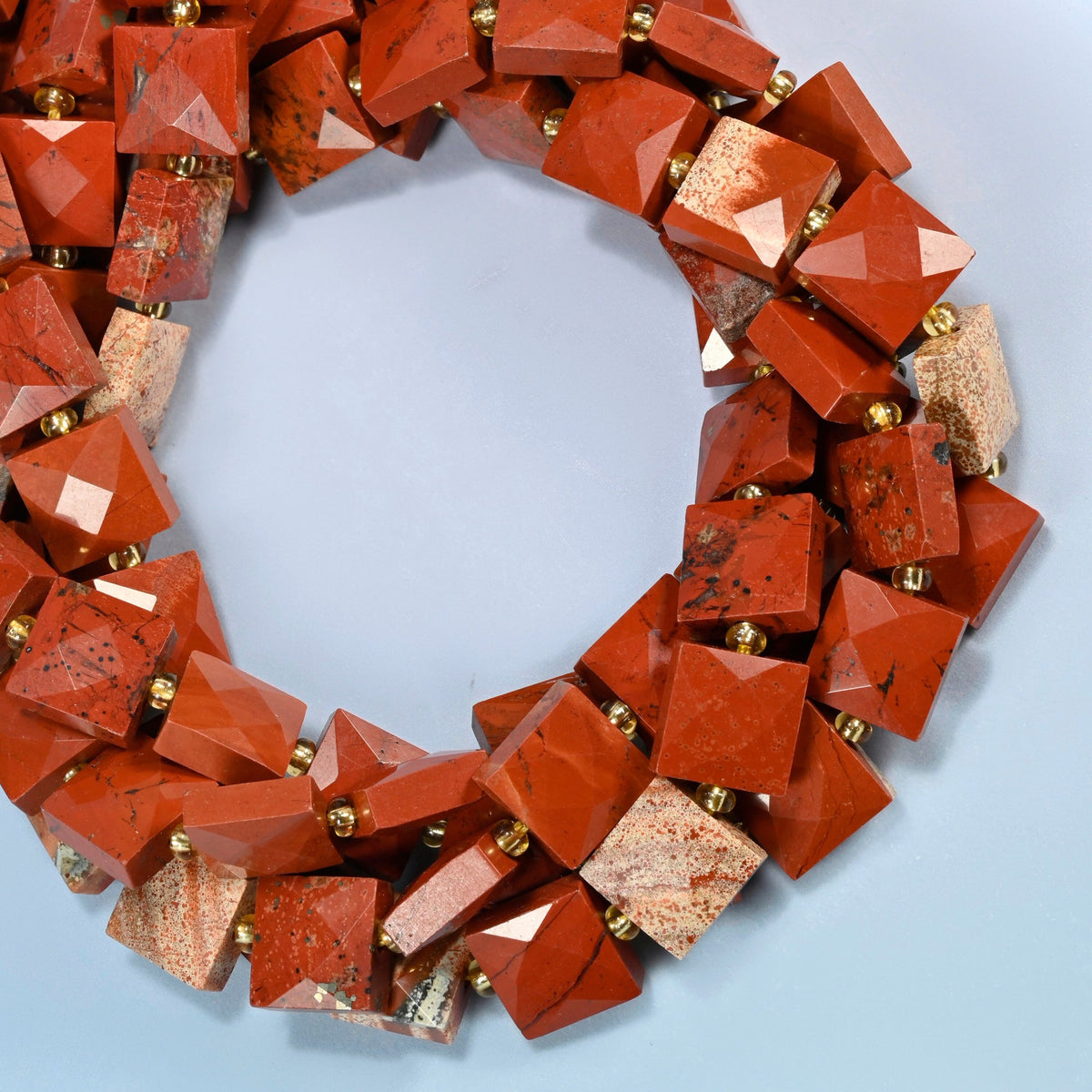 Natural flower red jasper faceted flat square beads coiled into overlapping loops, whole strands of brick red and cream stone