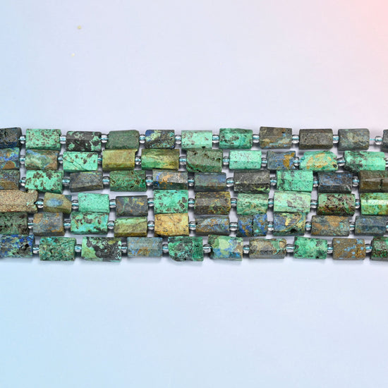 Four strands of azurite chrysocolla faceted tube beads laid in straight rows with clear seed bead spacers