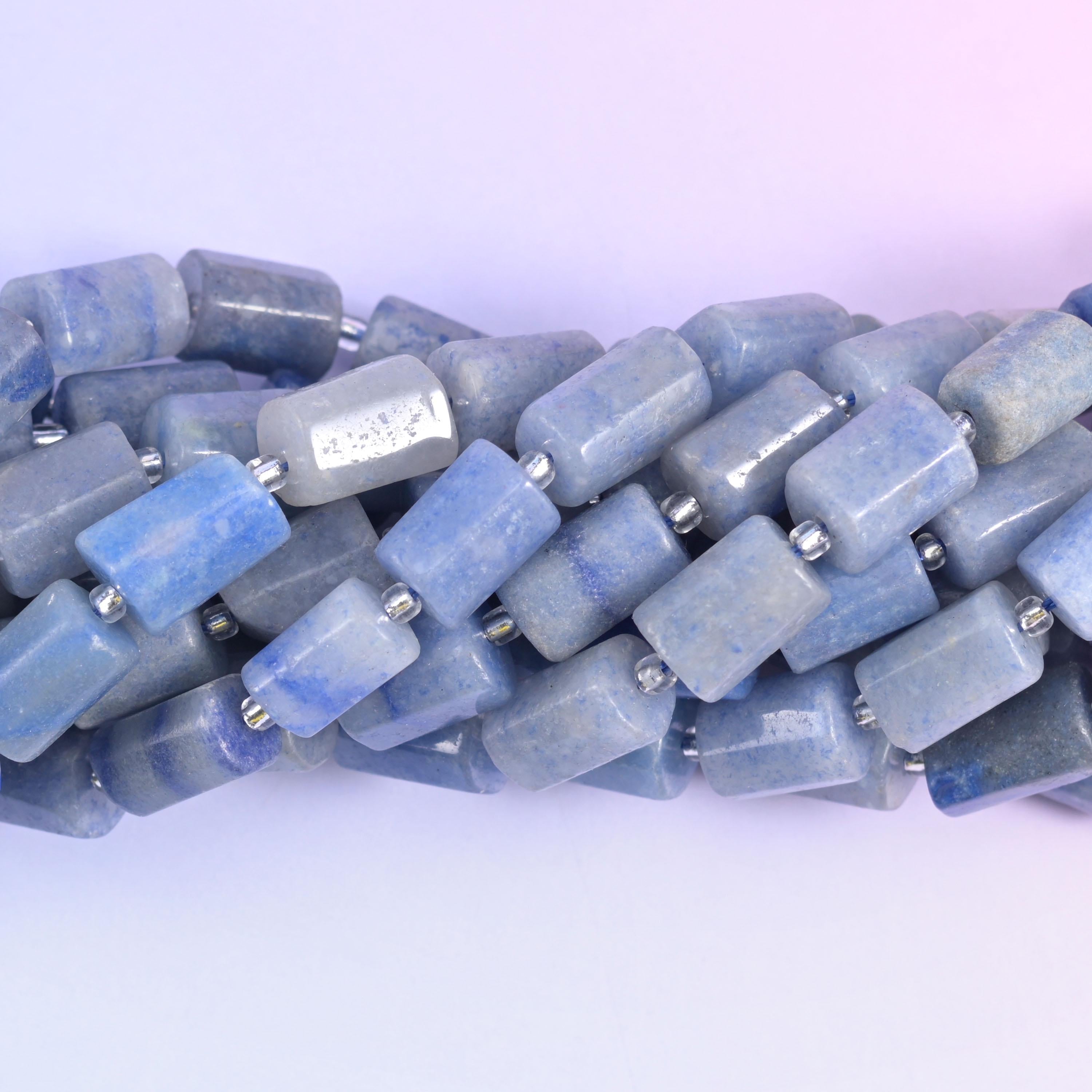 Macro view of aventurine tube beads, denim blue mottled with pale grey across the flat cut sides