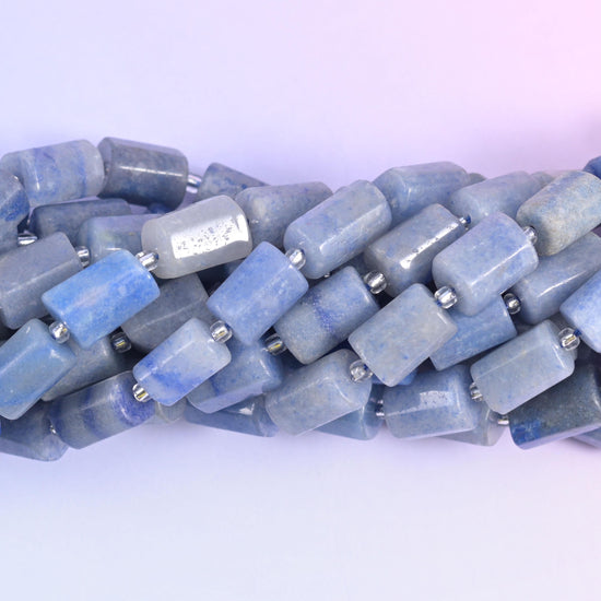 Macro view of aventurine tube beads, denim blue mottled with pale grey across the flat cut sides