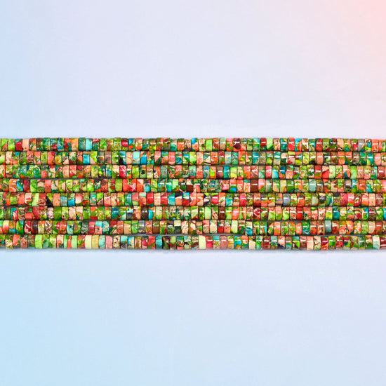 Several strands of dyed blue green sea sediment jasper heishi disc beads 2x4mm laid in straight rows, green and coral discs side by side