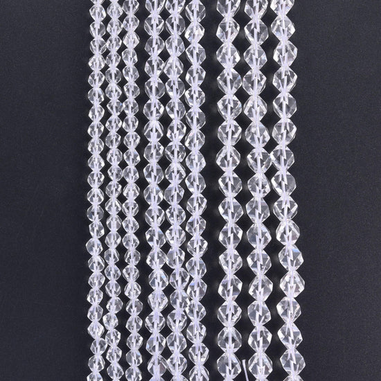 Clear Quartz diamond star cut beads, strands hanging vertically against a black background