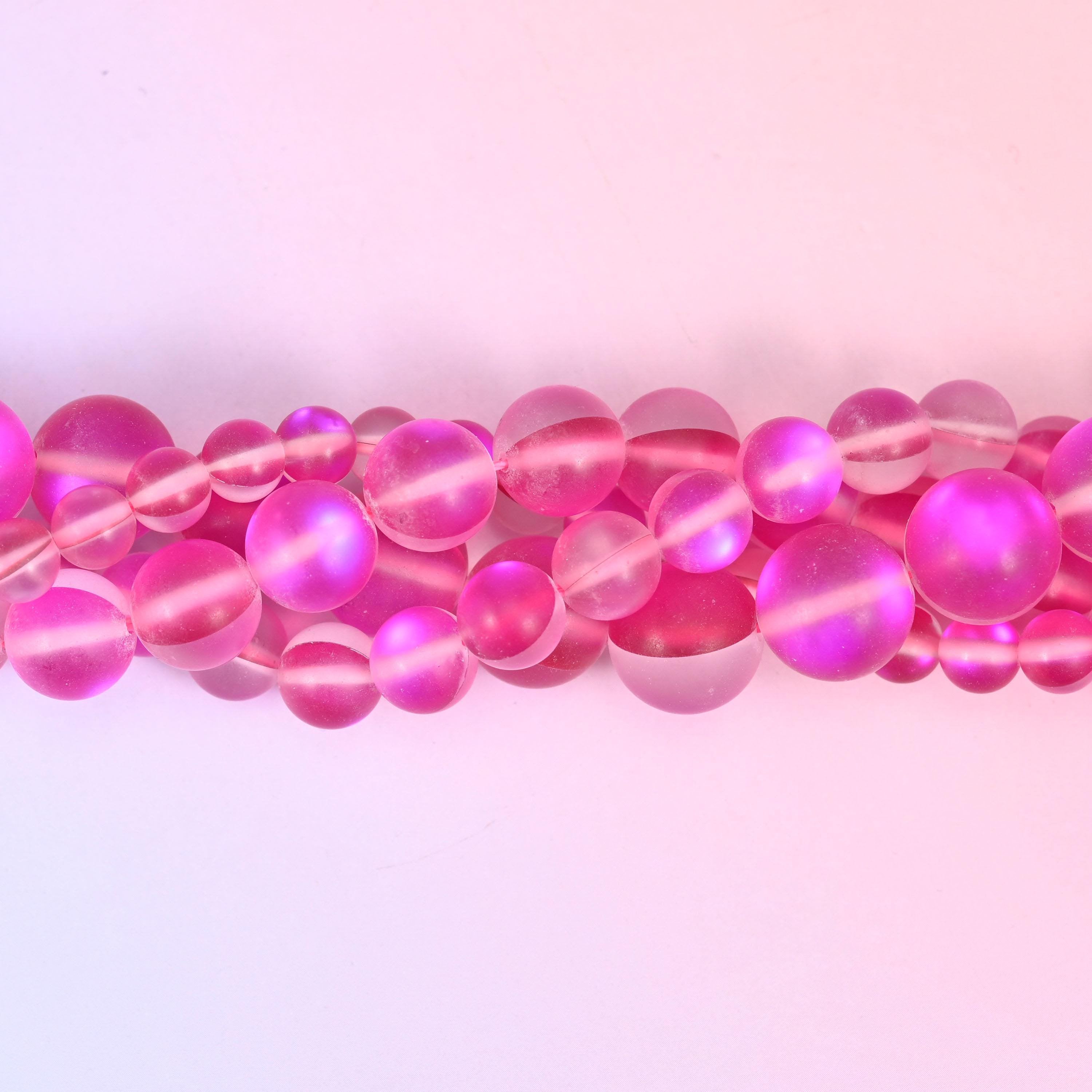 Frosted raspberry-pink glass beads with a soft sanded surface and aura core
