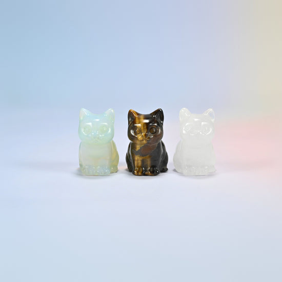 Three 1.5 inch sitting cat crystal carvings in opalite, natural tiger eye and natural clear quartz